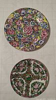Top view of both hand-painted Chinese floral plates showing detailed flower patterns and color.