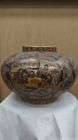 Front view of the wide round hand painted Japanese vase showing detailed cultural scenes and floral patterns.