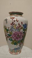 Front view of hand painted ceramic vase showing detailed floral and bird artwork
