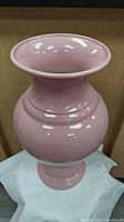 Front view of large light pink glossy ceramic vase showing flared rim and rounded body shape