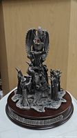 Front view of vintage pewter statue figurine showing gem dragon and wizards on wooden base with engraving.