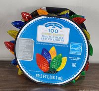 Front side of the packaging showing branding, bulb colors, length of light string (59.5 ft), and energy-saving information.