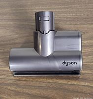 Top view of gray Dyson V6 Mini motorized vacuum head brush showing the brand name on the side and the attachment interface.