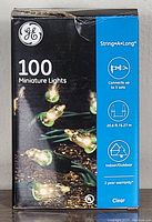 Front of box showing GE brand, 100 miniature clear lights, 20.6 ft length, indoor/outdoor use, connects up to 5 sets, 2 year warranty