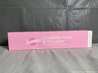 Pink rectangular packaging box showing 'Heroine Chopstick Styler' branding in white text.