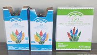 Front view of three boxes of Holiday Time Christmas lights showing quantity, type, and color.