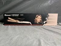 Box of Hoson Professional Hair Curler XB399 showing brand and features including ceramic barrel, anti-scald design, and 360° swivel cord.