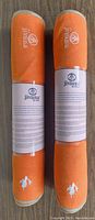 Photo of two rolled Jivana hot yoga mats with labels and branding visible.