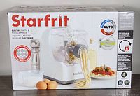 Front view of the product box showing the Starfrit branding and product image with pasta extruding from the machine.