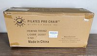 Box packaging for Pilates Pro Chair showing branding, item number, and manufacturing details