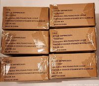 Photo of six sealed original brown boxes labeled 'Wolfgang Puck 1.5 cup Portable Cooker Steamer with Glass Lid' stacked in two columns; boxes show product style number and manufacturing details.