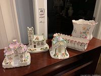 Overview of three house models and two planters on wooden surface