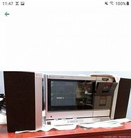 Front view of main unit flanked by two speakers showing tinted glass and speaker cloth