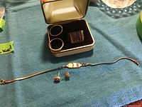 Overview of two rings in case plus bracelet and earrings arranged on cloth