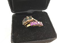 Two gold rings displayed in black velvet box