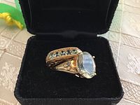 Two rings in black velvet box showing solitaire ring with oval stone and matching band