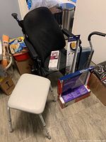Black wheelchair with obusforme back, packing boxes and other medical aids around it