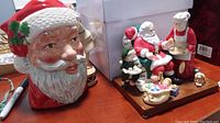 Photo of Santa Claus ceramic head figure close-up showing detailed facial features and red hat.