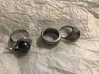 Three rings arranged on paper background showing all designs