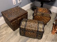 Front angled view showing all three trunks, highlighting woven wicker pattern and mixed shapes