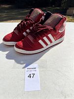 Pair of red Adidas high-top sneakers showing lateral side and front