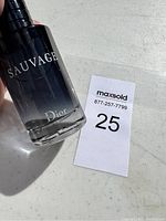 Close-up of 'Sauvage Dior' text on the bottle with partial view of the liquid inside showing about 95% full.