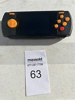 Front view of handheld Atari gaming device showing screen and controls.