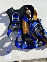 Full harness showing blue and yellow straps with black padding and metal attachment ring.