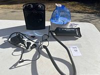 Full view of the heater, humidifier, and inflatable air pump placed on a white table outdoors in daylight.