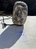 Salt rock lamp with visible power cord shown from one side under natural light.