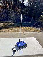 Photo of the full Shark rechargeable vacuum with handle standing upright on a table outdoors.