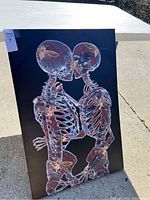 Front view of the skeleton canvas artwork showing detailed skeleton couple with butterflies on a dark background.