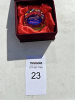 Glass collectible paperweight with Space Shuttle Atlantis text and image in a red satin-lined maroon box.