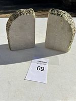 Pair of stone bookends shown from the front with rough arched tops and smooth flat sides