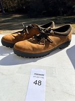 Side and top view of brown Timberland men's shoes size 12 with laces on white surface outdoors.