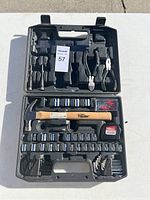 Overview of HYDE TOUGH tool set in black molded plastic carrying case showing hammer, pliers, tape measure, sockets, and bits.