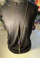 Necklace shown on black mannequin showcasing length and pendant placement.
