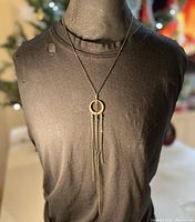 Full view of the antique copper filigree half moon pendant necklace displayed on a black fabric bust, showing the overall length and style of the necklace.