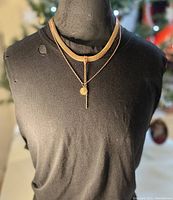 Copper necklace with peace dove pendant on fine copper chain and snake chain accent displayed on black mannequin torso.