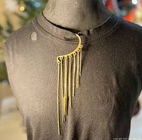 Gold plated ear cuff displayed on a mannequin wearing a dark top showing the vertical gold chains and spike drop.