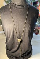 Full view of the bronze heart pendant necklace on black fabric background showing length.