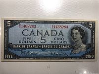 Front of the 1954 Canadian five dollar bank note showing the portrait of Queen Elizabeth II and serial number E/5 1468283.