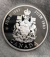 Close up image of one side of the silver proof medal showing Canadian Coat of Arms with date June 1983 and 'Canada' inscription.