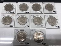 Overview of 10 Canadian 1 dollar coins from 1968 to 1977, each in a holder with the year noted.