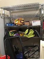 Metal wire shelf unit filled with various household items for contextual view and condition assessment.