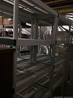 Side view of two stacked shelving units showing four open slatted shelves