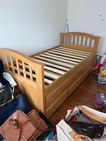 Full view of light wood twin trundle bed frame with six drawers underneath and slatted mattress support