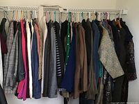 Wide view of women's jackets hanging on rack showing variety of colors, patterns, and styles