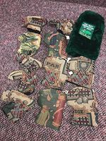 12 golf club covers laid out on carpet, 11 with patterned fabric golf motifs, 1 green furry cover