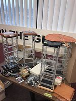 Photo showing five clear acrylic multi-tier display units arranged on a table, with multiple golf accessories placed around them.